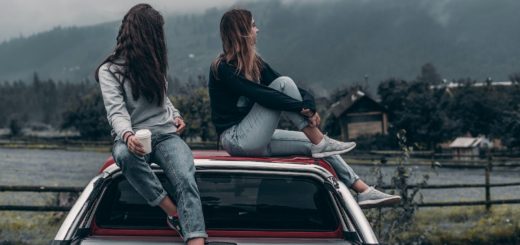 two women sitting on vehicle roofs