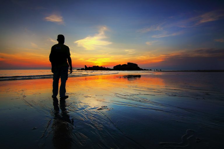 silhouette of man standing on seashore