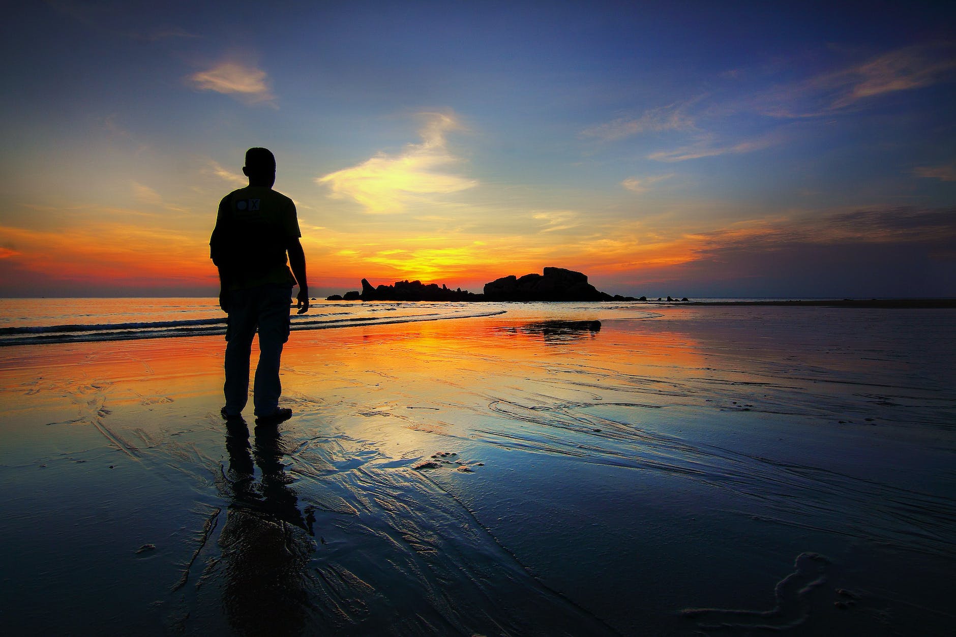 silhouette of man standing on seashore