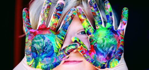 a kid with multicolored hand paint