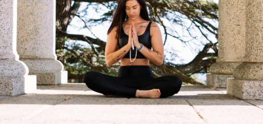 woman in black tank top and black pants sitting on concrete floor