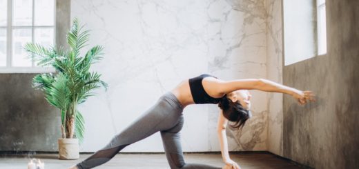 woman in gray leggings and black sports bra doing yoga on yoga mat