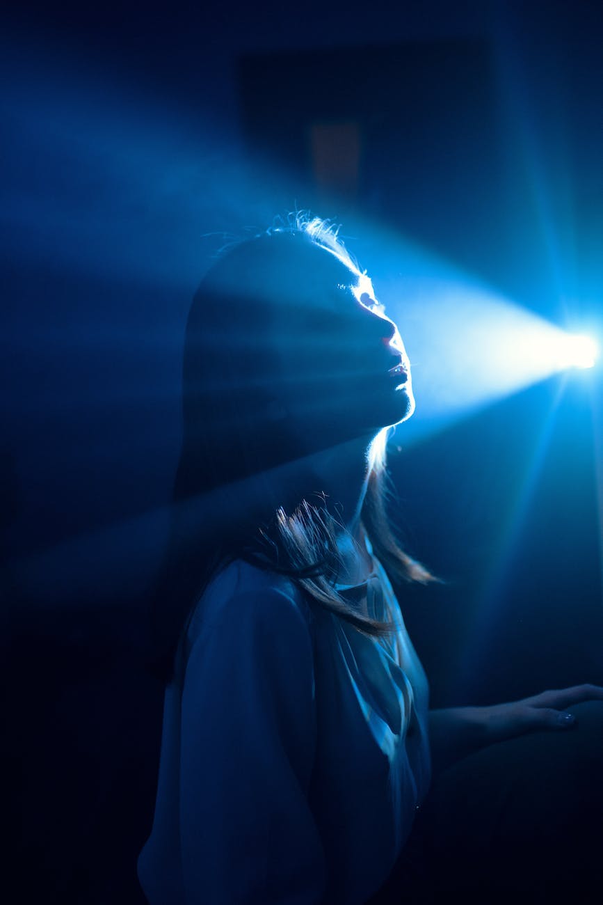 sensitive woman in shiny blue light ray