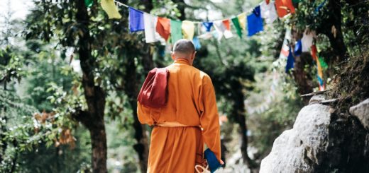 monk walking near buntings during day