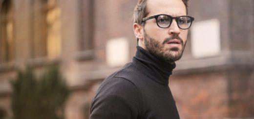 man standing near building white black turtleneck shirt