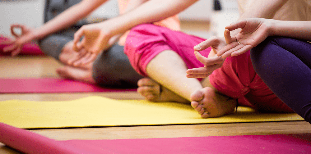 group of woman performing yoga together