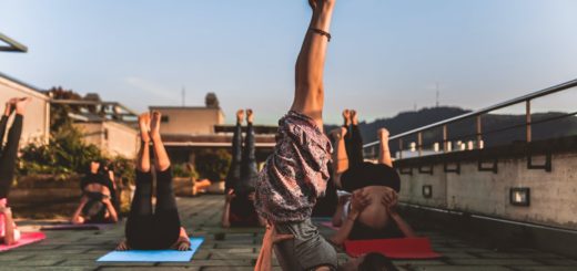 group of women lying on yoga mat under blue sky