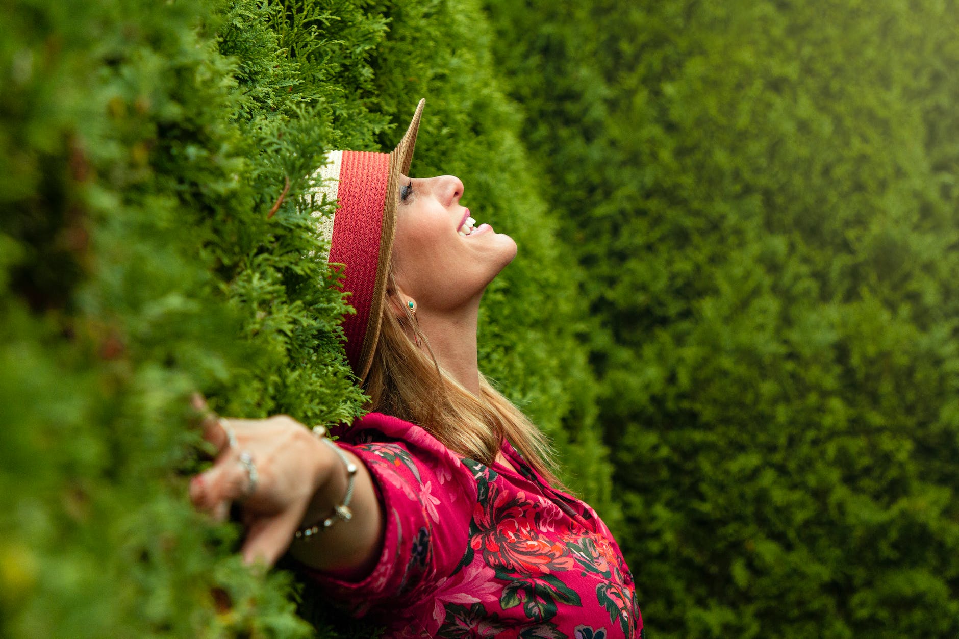 woman in red floral shirt lying on grass field