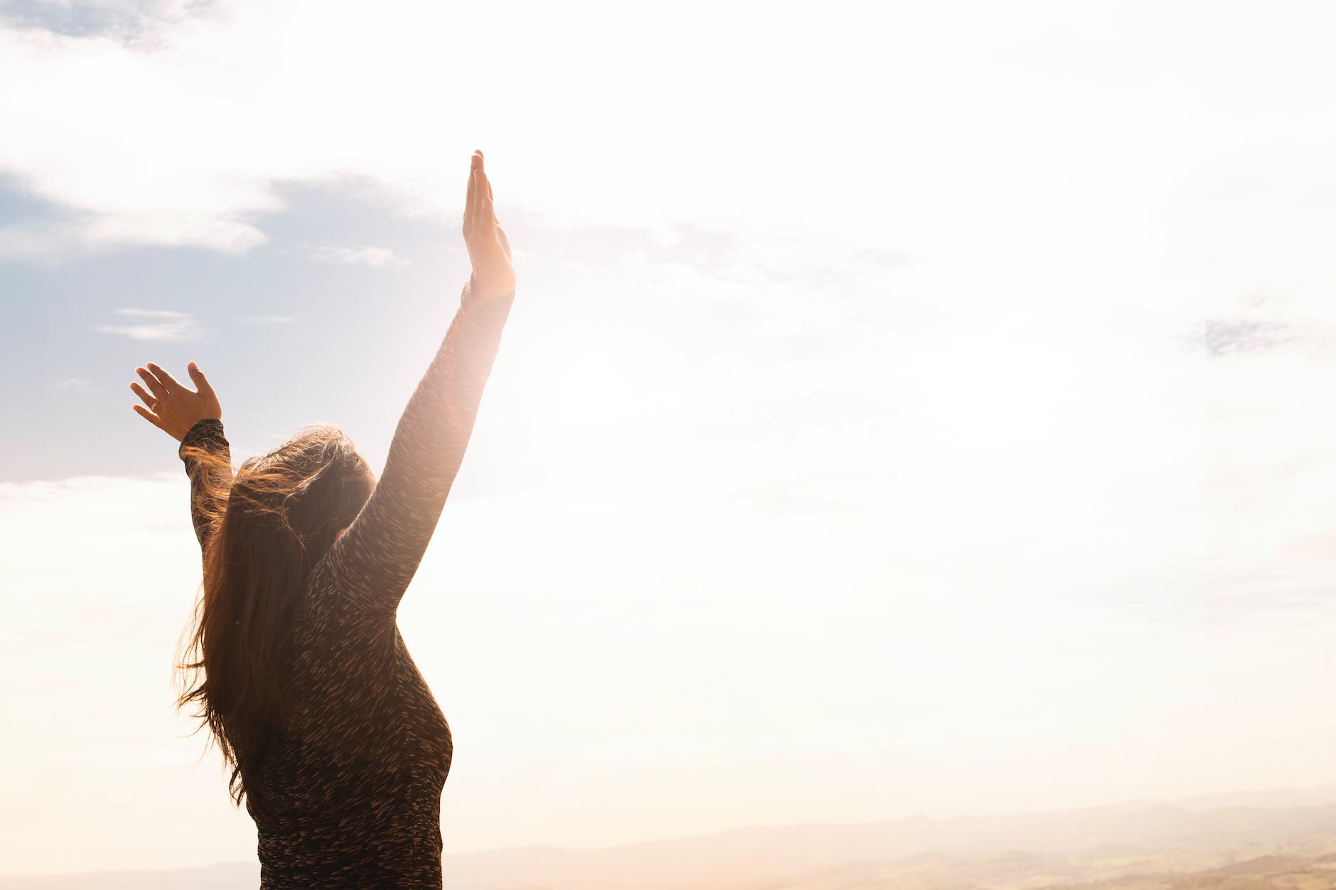 photo of woman raising both hands