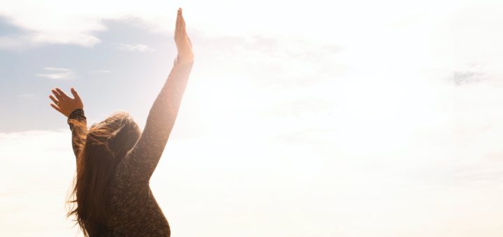 photo of woman raising both hands