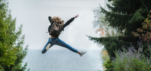 woman jumping wearing green backpack