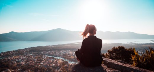 woman sitting at the edge of mountain