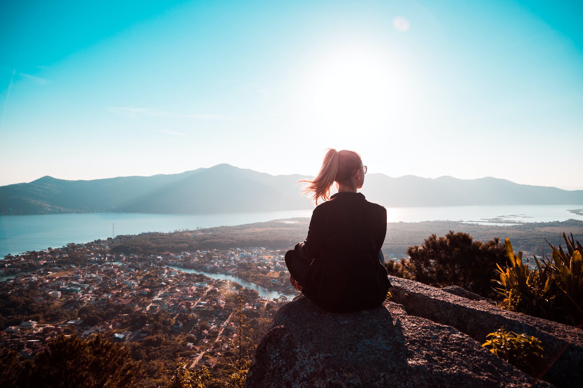 woman sitting at the edge of mountain