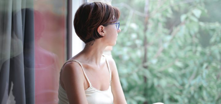 pensive woman looking at window