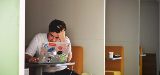 man in white shirt using macbook pro