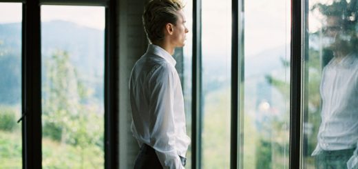 calm well dressed male standing near window at home