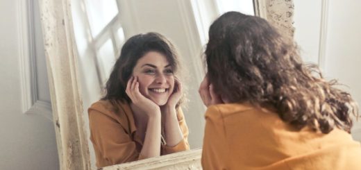 photo of woman looking at the mirror