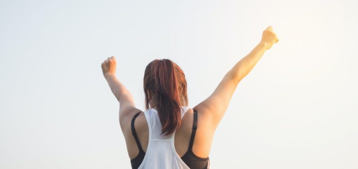 woman wearing black bra and white tank top raising both hands on top