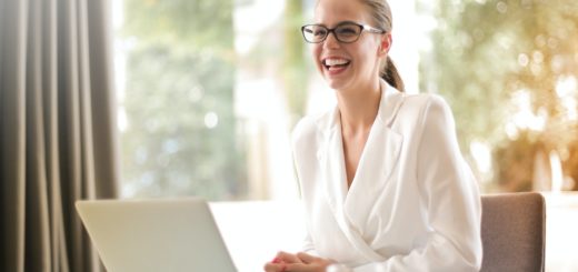 laughing businesswoman working in office with laptop