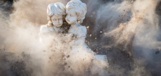 two white concrete statues covered by dust