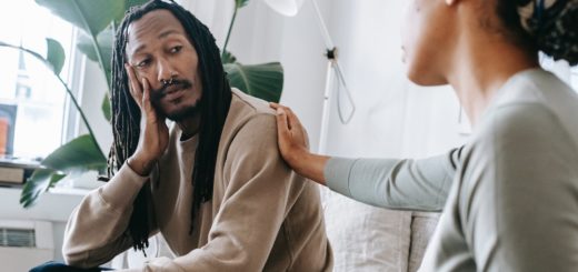 ethnic psychologist touching black depressed clients shoulder