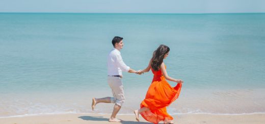 man and woman walks beside green sea