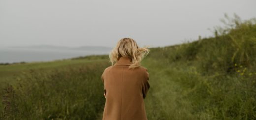 anonymous woman walking in cold field