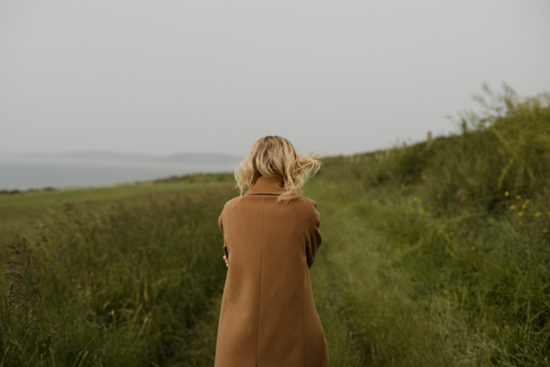 anonymous woman walking in cold field