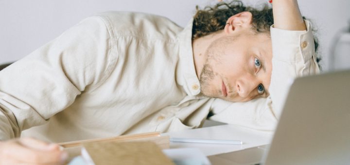 overworked employee lying in front of laptop