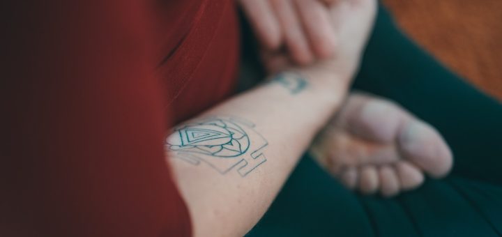 person with black and red tattoo on right arm