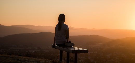 woman sitting on bench over viewing mountain