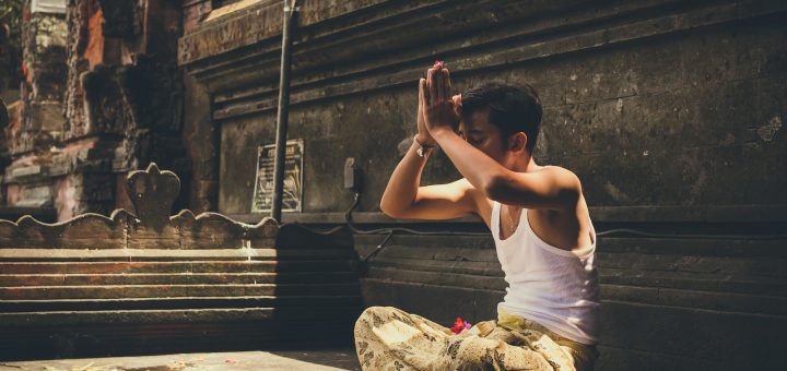 man in white tank top praying