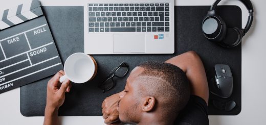 a man sitting at a desk with a laptop and headphones