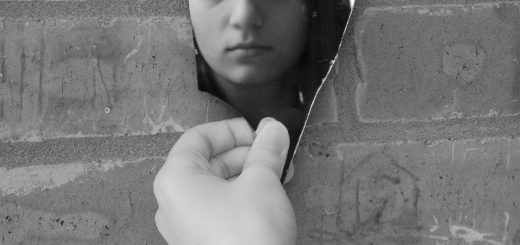 a woman leaning against a brick wall